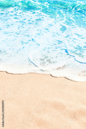 Blue ocean wave on sandy beach. Summer day and sand beach background
