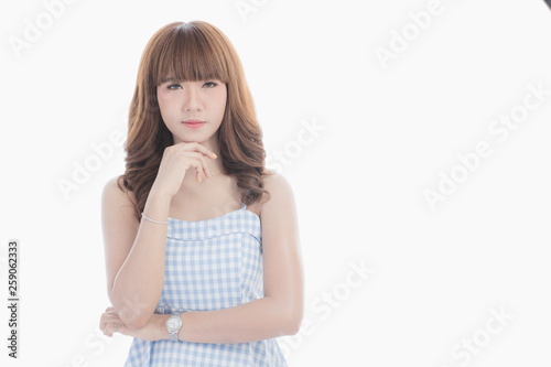 Front view close-up portrait of young beautiful Asian woman with curly long dark brown hair in light blue checked dress stand up straight  isolated white background © Bangkok Click Studio