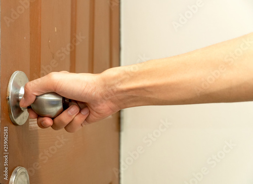 man’s hand reaching to door knob opening the door brown. clipping path. illustration