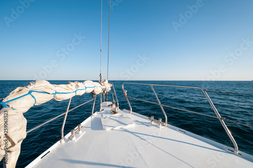 A wide angle shot of the front of the yacht in the summer sailing towards the horizon