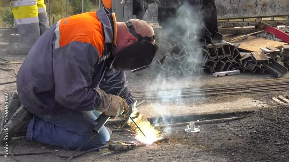 Welder with Shield Metal Arc Welding process in steel fabrication structure factory. Close-up worker with protective mask welding metal. Welder with Shield Metal Arc Welding process in steel fabrication structure factory. Close-up worker with protective mask welding metal.