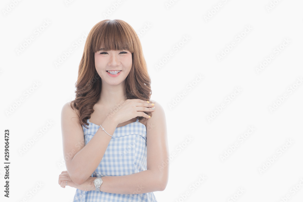 Front view close-up portrait of young beautiful Asian woman with curly long dark brown hair in light blue checked dress stand up straight isolated white background Front view close-up portrait of young beautiful Asian woman with curly long dark brown hair in light blue checked dress stand up straight isolated white background