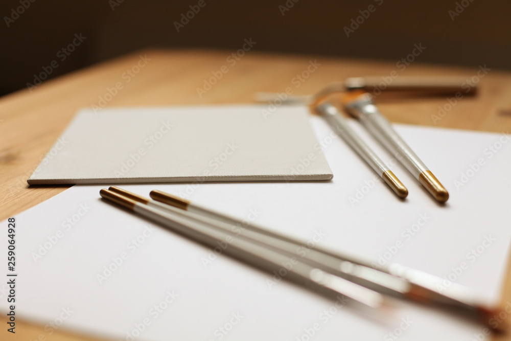 Empty canvas board with paintbrush on a wooden table Empty canvas board with paintbrush on a wooden table