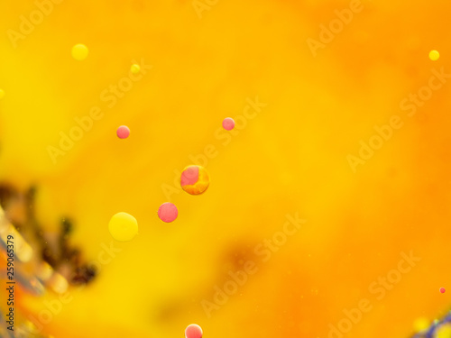 Yellow and pink bubbles in abstract universe. Close up macro shot. Blurred background. Selective soft focus. Orange abstract space with yellow and pink spheres, abstract orange pattern