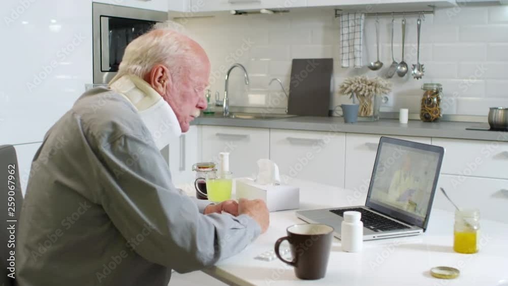 Medium shot of coughing aged patient with neck brace receiving online medical consultation Medium shot of coughing aged patient with neck brace receiving online medical consultation