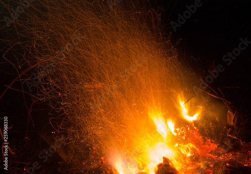 Burning fire in the night. Flame and fire sparkles on a dark abstract background. Hellish element of fire. Fuel, power and energy
