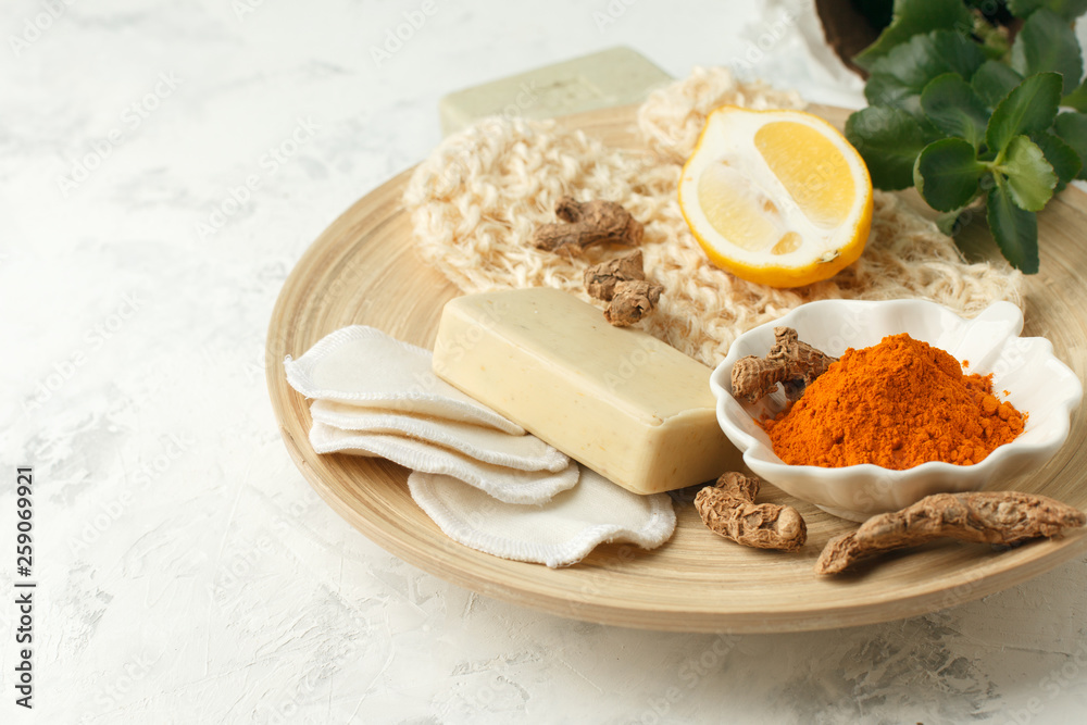 Home beauty products - turmeric, soap, scrub, sponges, lemon, soap, facial brush on light background, top view. Skin youthfulness, beauty concept. Flat lay Home beauty products - turmeric, soap, scrub, sponges, lemon, soap, facial brush on light background, top view. Skin youthfulness, beauty concept. Flat lay