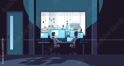two men looking at monitors sitting behind glass window people working in co-working open space office center dark room interior surveillance security system flat horizontal