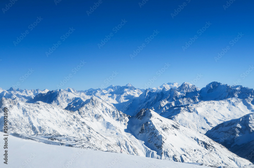Mountain range of Caucasian Mountains in the blue sky. Elbrus region