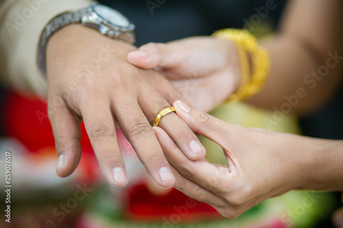 groom wears ring on bride's finger in wedding ceremony.wedding day