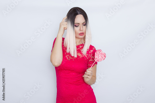 Blonde woman eating big heart candy