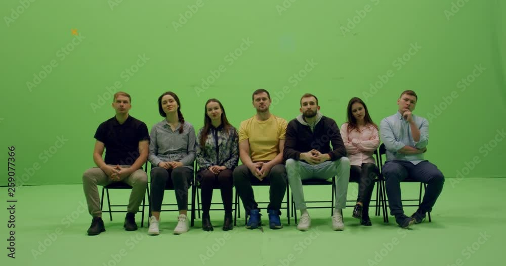 GREEN SCREEN CHROMA KEY Front view group of young people sitting and looking at something behind the camera. 4K UHD ProRes 4444