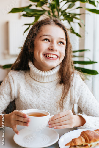 Smiling young girl having breakfast