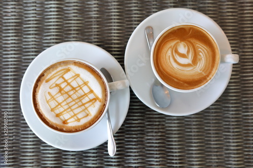 фотографія hot caramel macchiato and latte coffee drink put on table in cafe