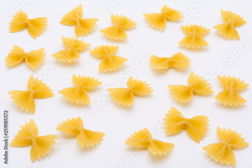 Pattern of raw farfalle pasta on white background