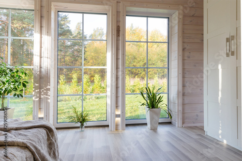 Bright interior, room in wooden house with large window. Scandinavian style.