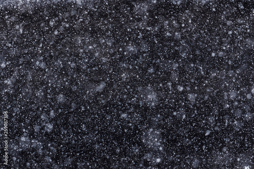 Lots of flying snowflakes on a dark background
