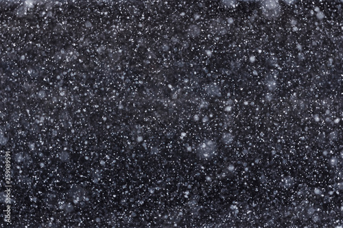 White spots on a black background, falling snow at night, snowfall