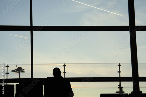 Homme de dos en attente à l’aéroport