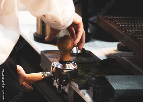 Barista working in a coffee shop, Close up of barista presses ground coffee using tamper, Barista Make Coffee Portafilter Concept