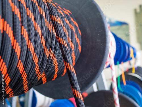 Black rope on a show-window of shop. A saving rope for climbers. The rope is reeled up on the coil