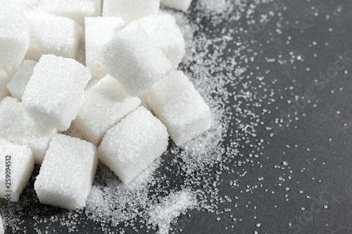 White sugar cubes over black background close up