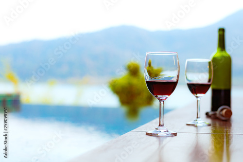 Two glasses of red wine near the swimming pool with a spectacular view of the sea