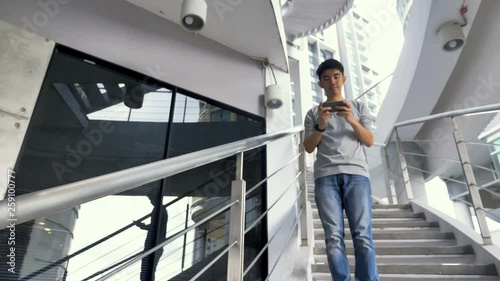 4K Clumsy Asian man  falling down from stairs, Accident by using smartphone photo