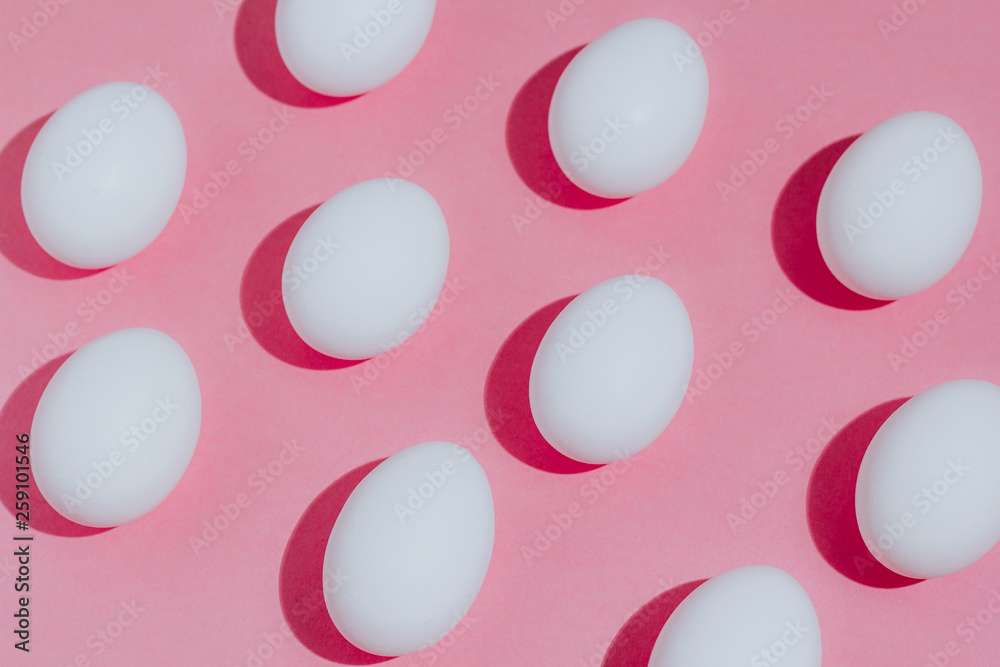 White chicken eggs with empty space, on a pink background. Abstract image White chicken eggs with empty space, on a pink background. Abstract image