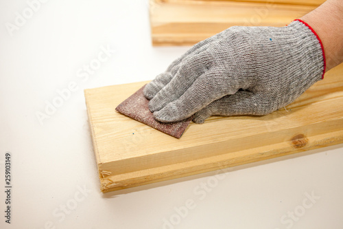 The man processes the Board with sandpaper. Polishing pine boards.