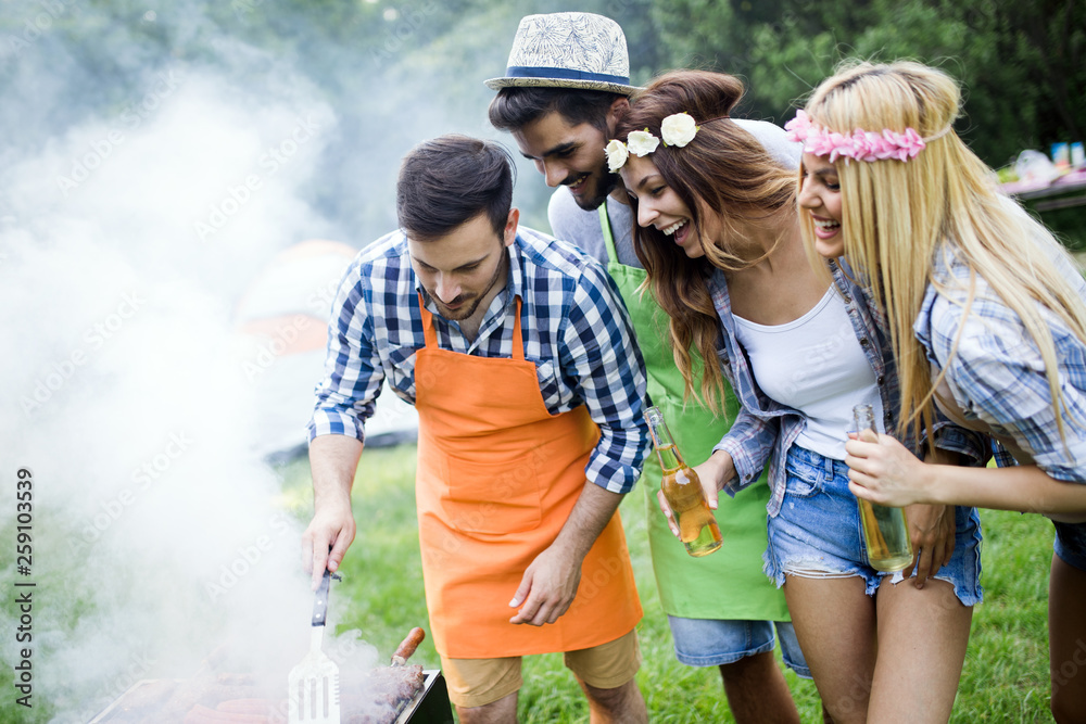 Group of friends making barbecue in the nature