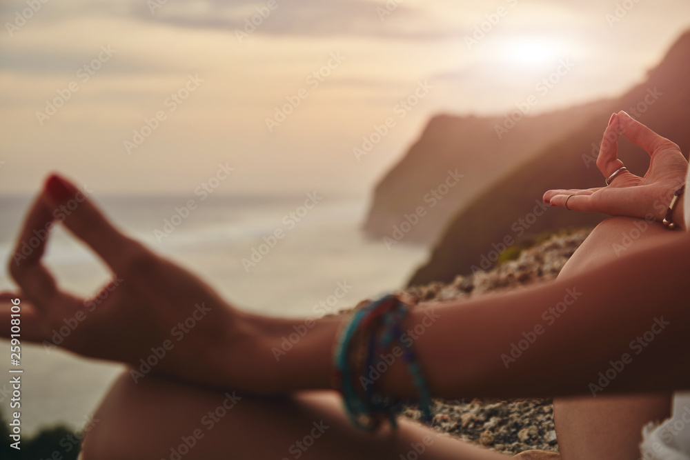Young woman practicing yoga - meditation on the beach.