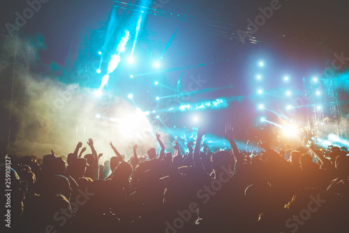 Happy people dancing and having fun in summer music festival party outdoor - Soft focus on center hand up with blue flare - Fun and youth concept