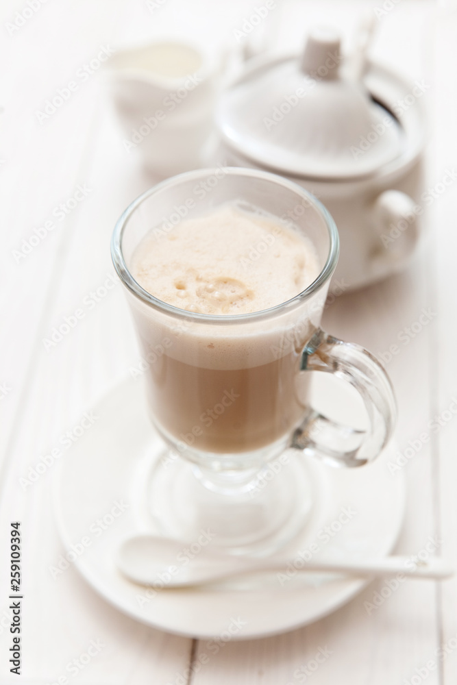 Raf coffee in transparent glass on a light wooden background. Delicious Russian most popular drinks. Raf coffee in transparent glass on a light wooden background. Delicious Russian most popular drinks.