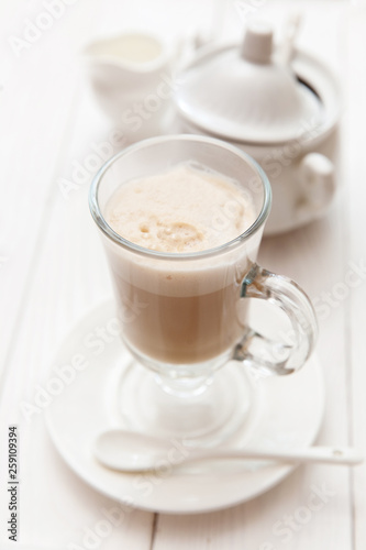 Raf coffee in transparent glass on a light wooden background. Delicious Russian most popular drinks. 