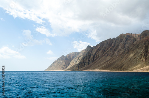 blue sea and high rocky mountains against the sky and clouds in Egypt Dahab South Sinai
