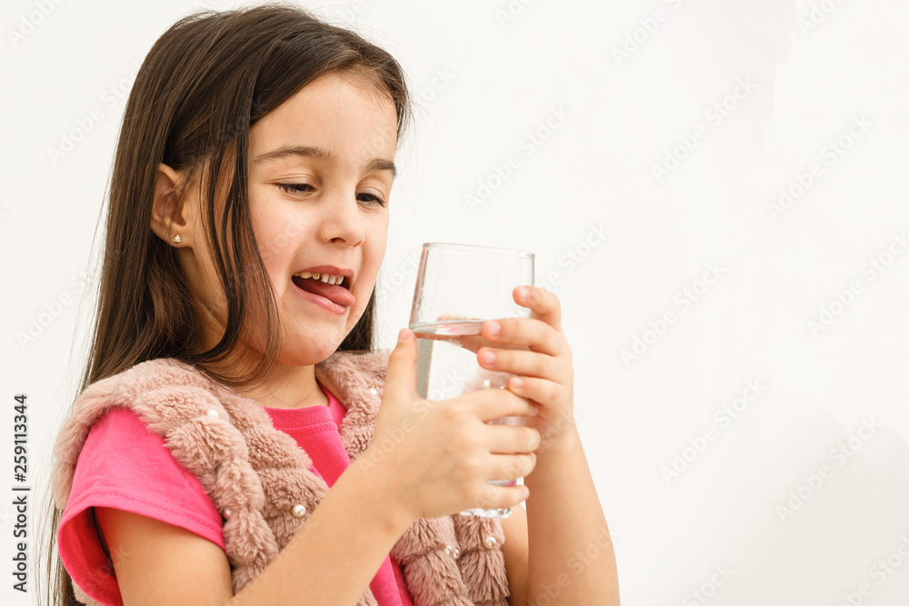 Smiling little girl with a glass of water on a white background Smiling little girl with a glass of water on a white background