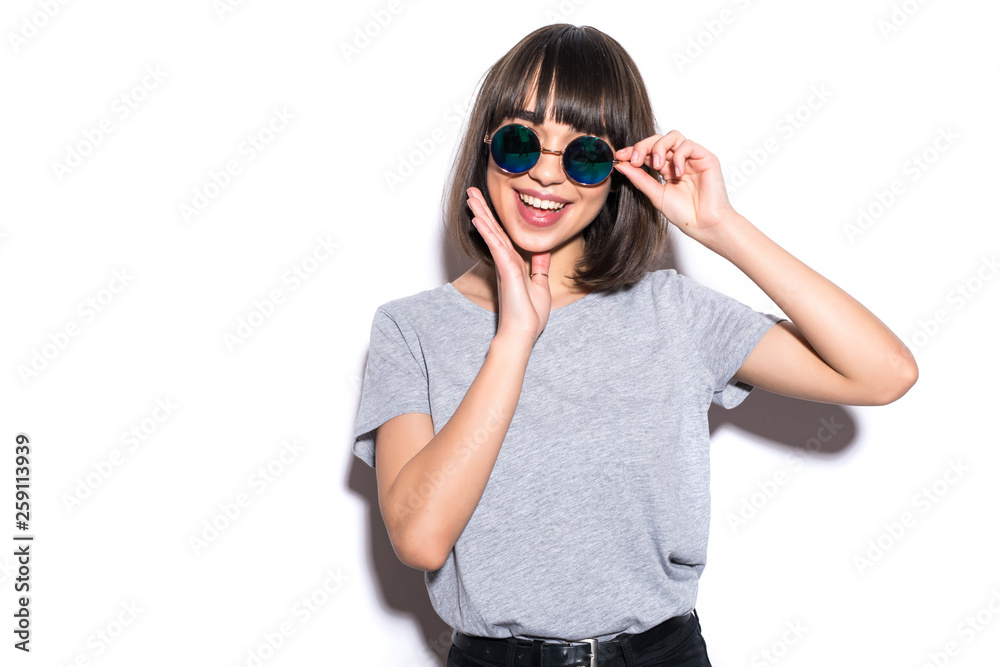 Pretty young woman posing on white wall background dressed in hipster style jeans outfit on White background