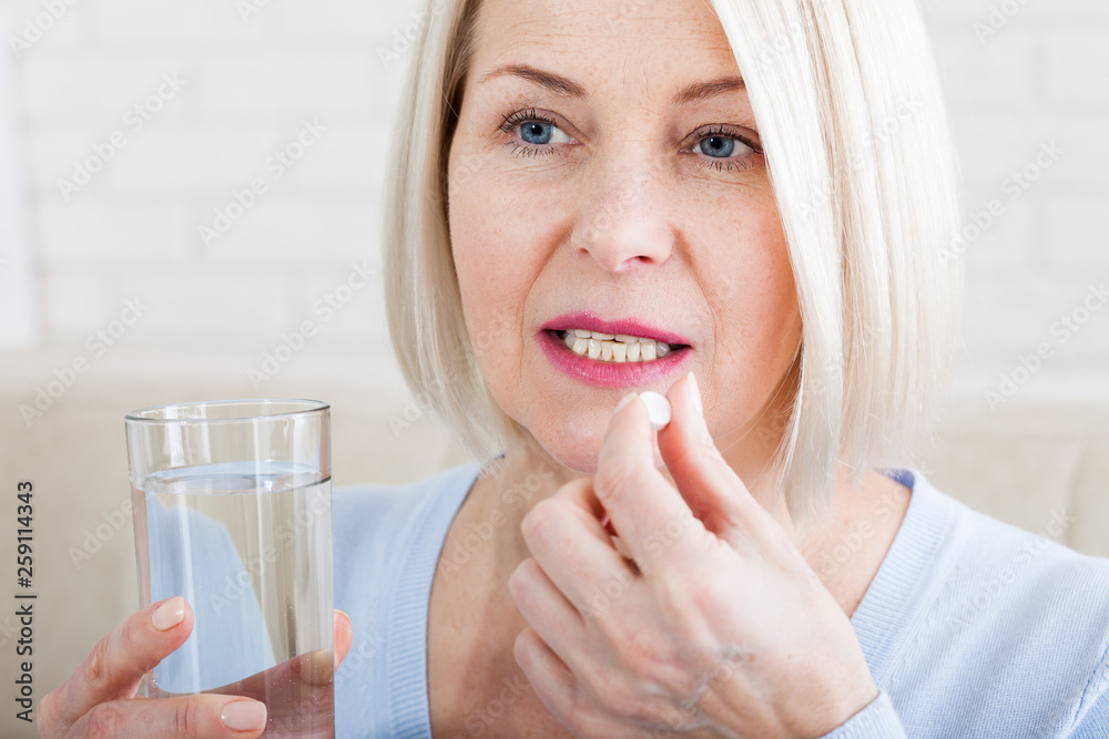 medicine, health care and people concept, close up of middle aged woman taking in pill medicine, health care and people concept, close up of middle aged woman taking in pill