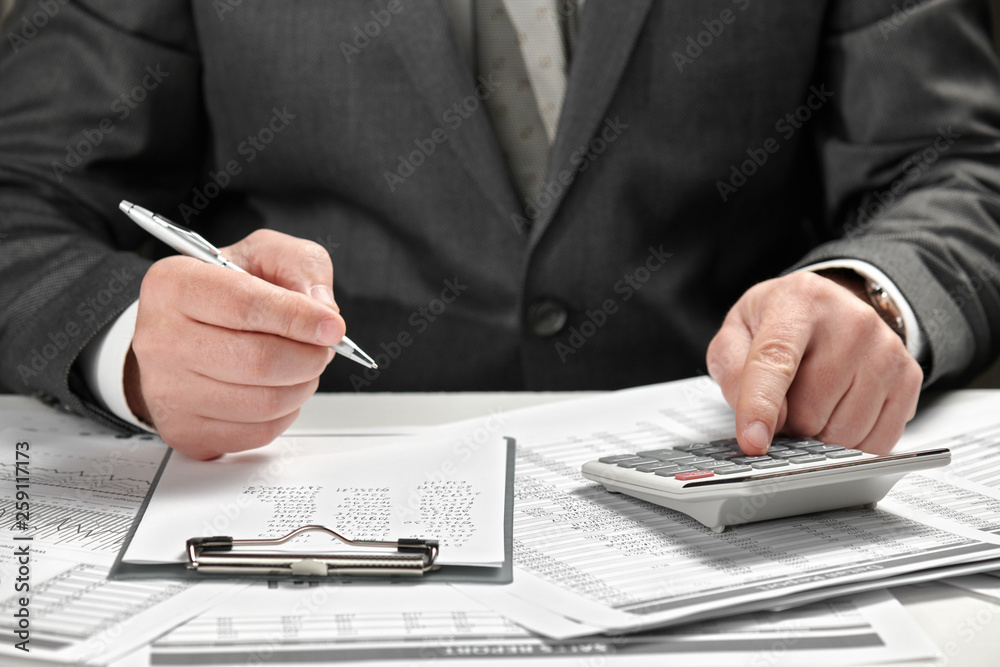 Businessman working in an office. Hands and documents closeup.