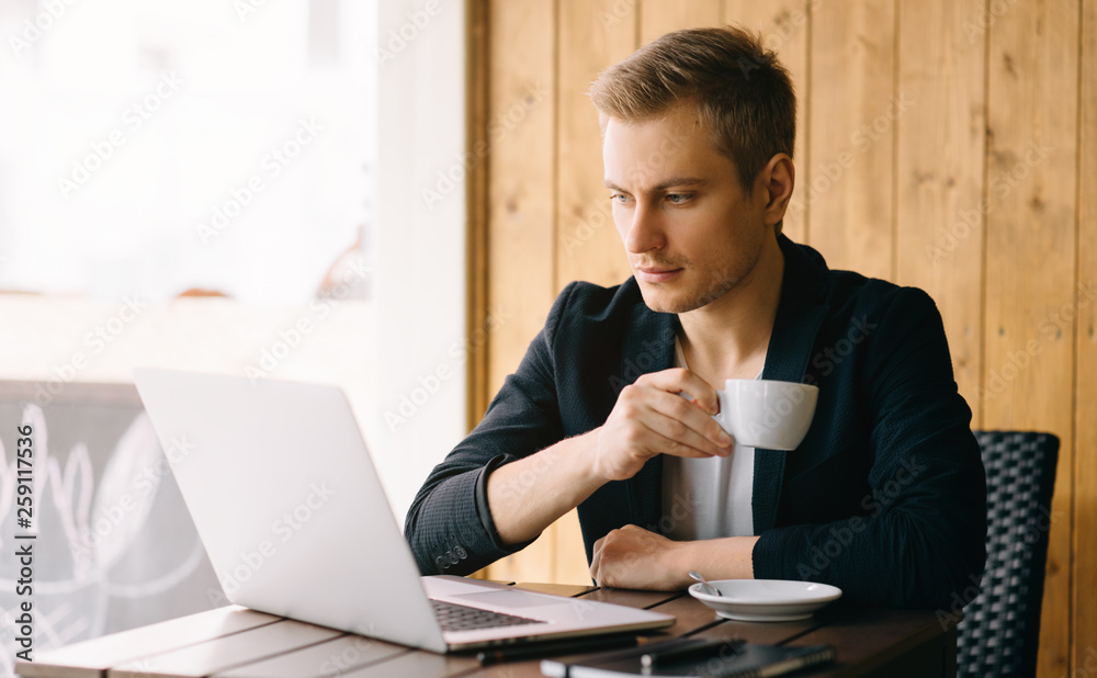 Fototapeta premium Stylish young man calling by the phone to solve business problems. Online consultation by phone. Freelancer discussing the development and planning of his online project. Outsourcing. Mobile services.