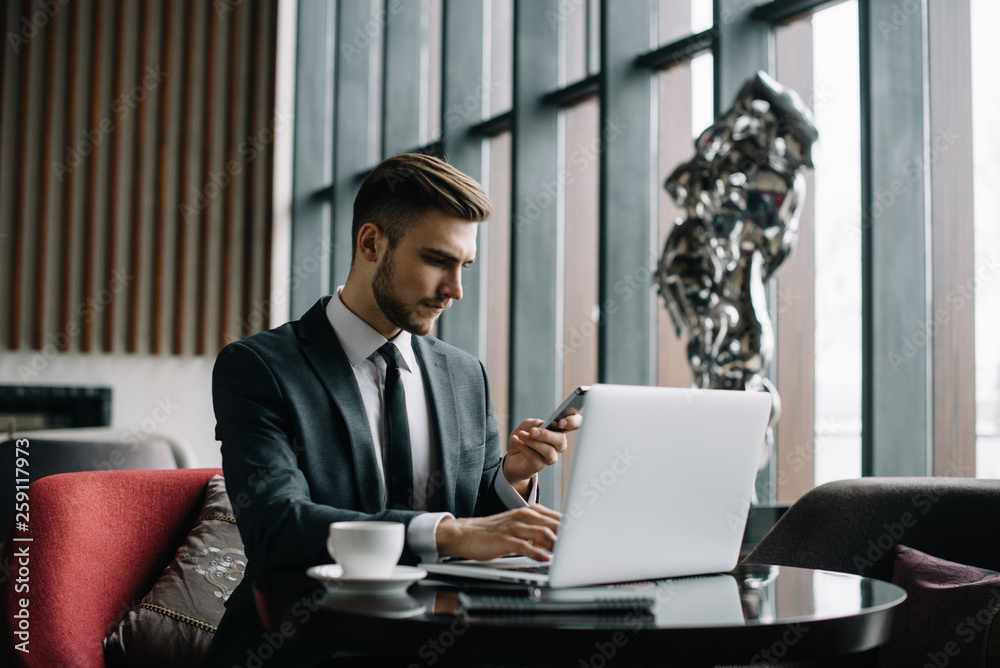Fototapeta premium Young handsome businessman conducting negotiations with investors. Electronic business. Alternative payment services. Management of the projects on freelance. Cryptocurrency. Blockchain. Trader.