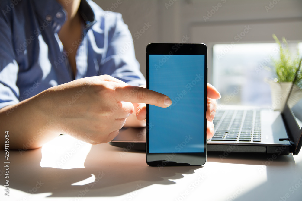Woman hand holding a modern mobile smart phone with blank blue screen Woman hand holding a modern mobile smart phone with blank blue screen