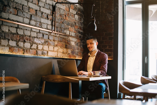 Young businessman working on a plan of Internet project on the laptop. Man discusses business matters by phone. Working computer for internet research. Digital marketing. Development