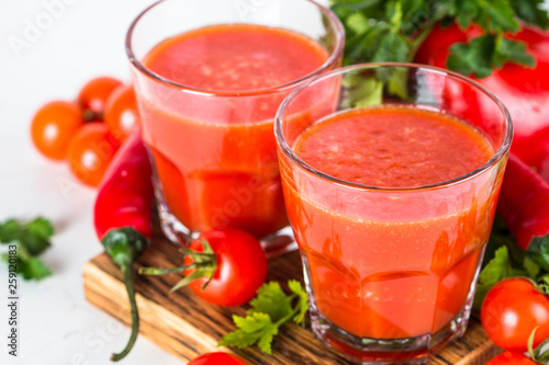 Tomato vegetable juice in glass on white.