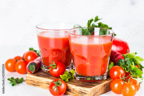 Tomato vegetable juice in glass on white.