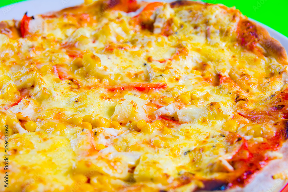 hot tasty fresh pizza on a plate close-up. green background hot tasty fresh pizza on a plate close-up. green background