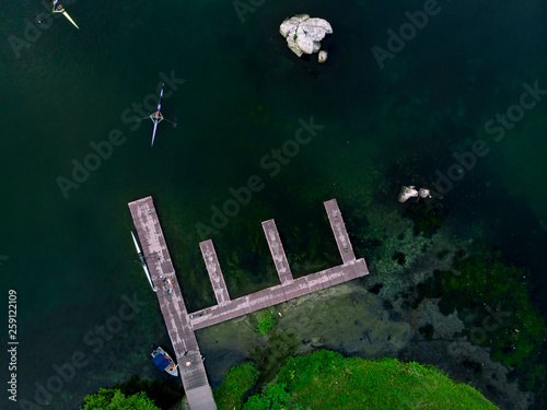 Pier in the city lake of Rio de Janeiro with rowing boats seen from a high altitude above. Landing stage competitive crews top down view. photo