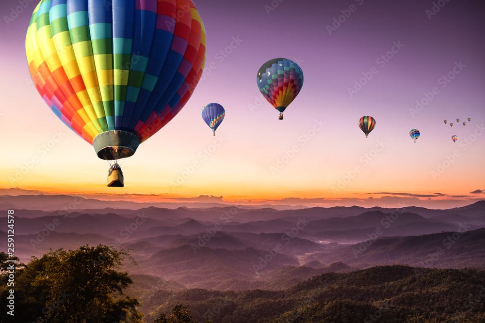 Naklejka premium purple sky sunset hot air Colorful balloon flying with scenery beautiful romantic mountain hill and fog in Chiang Mai , Thailand.
