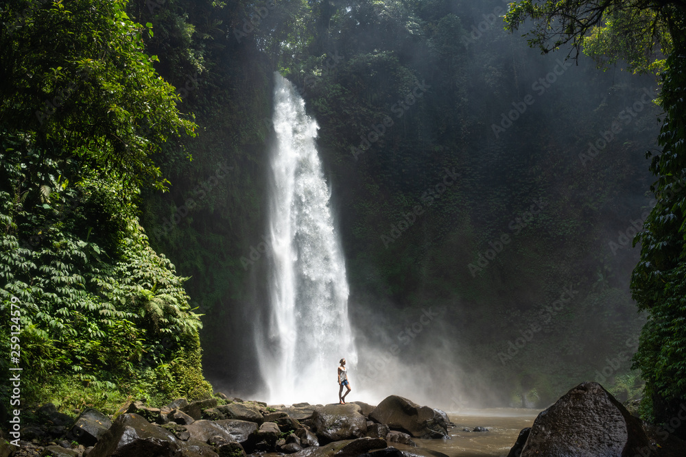 Adventure seeker at beautiful jungle waterfall